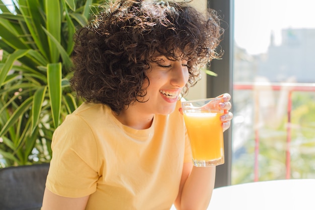 Foto mulher jovem e bonita bebendo suco