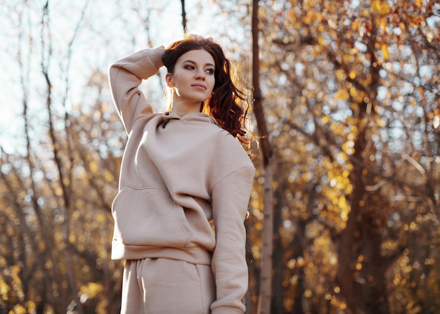 Mulher jovem e bonita caminhando ao ar livre no parque ensolarado