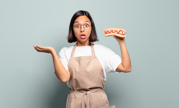 Mulher jovem e bonita chef com cachorro-quente