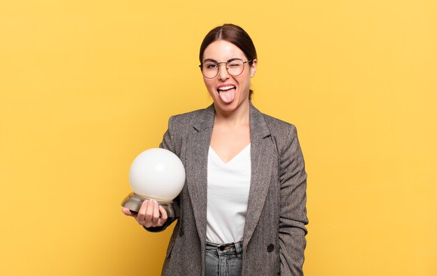 Mulher jovem e bonita com atitude alegre, despreocupada e rebelde, brincando e mostrando a língua