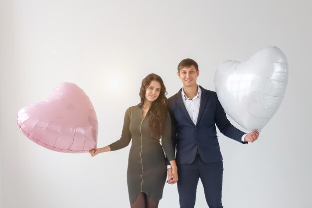 Mulher jovem e bonita com balão de ar de forma de coração em fundo branco com espaço de cópia. Mulher no Dia dos Namorados. Símbolo de amor.