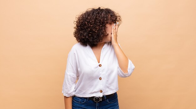 mulher jovem e bonita com cabelo encaracolado e uma camisa branca