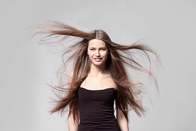 Mulher jovem e bonita com cabelo longo e reto sobre fundo claro