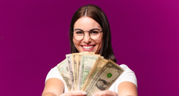 Mulher jovem e bonita com notas de dólar