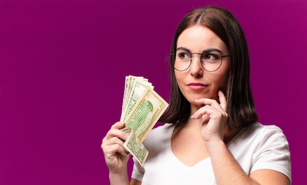 Mulher jovem e bonita com notas de dólar