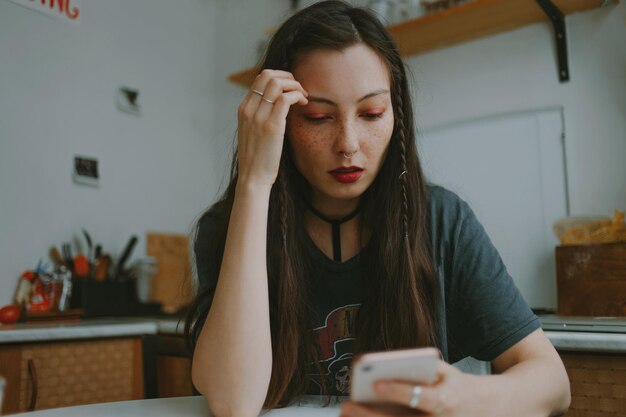 Foto mulher jovem e bonita com o smartphone em casa.