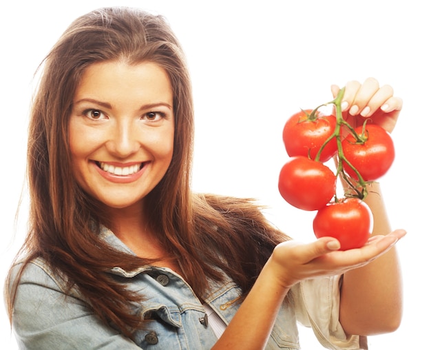 Mulher jovem e bonita com tomates maduros