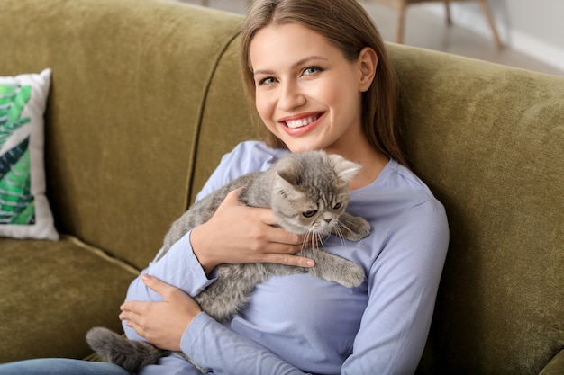 Mulher jovem e bonita com um gato fofo em casa