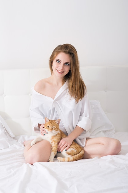 Mulher jovem e bonita com um gato vermelho