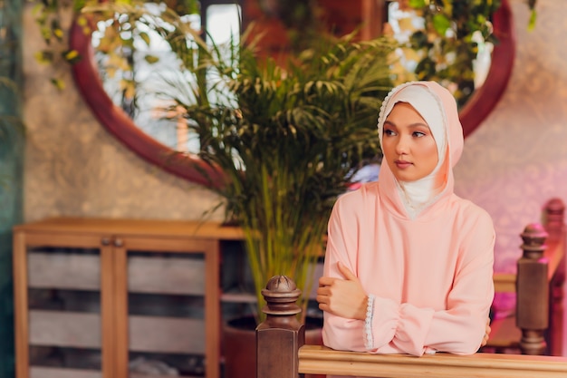 Mulher jovem e bonita com um hijab rosa.