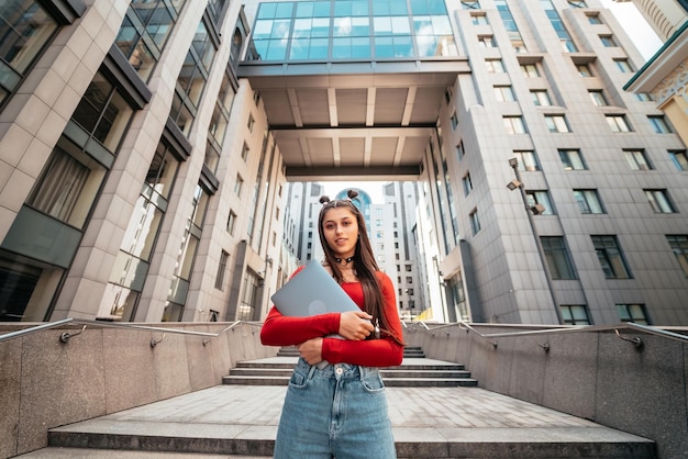 Mulher jovem e bonita com um laptop na rua