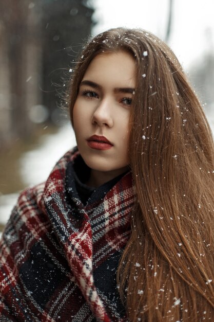 Mulher jovem e bonita com um lenço da moda ao ar livre em clima de neve