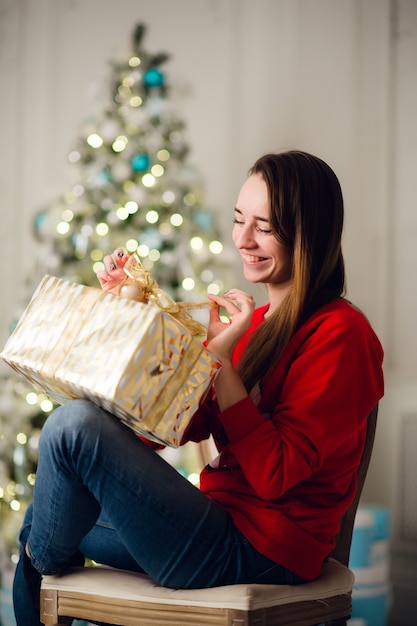 Mulher jovem e bonita com um presente de Natal