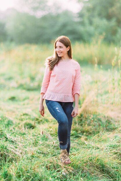 Mulher jovem e bonita com uma camisa rosa na natureza