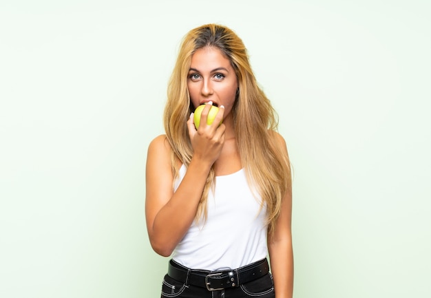 Mulher jovem e bonita com uma maçã sobre fundo isolado