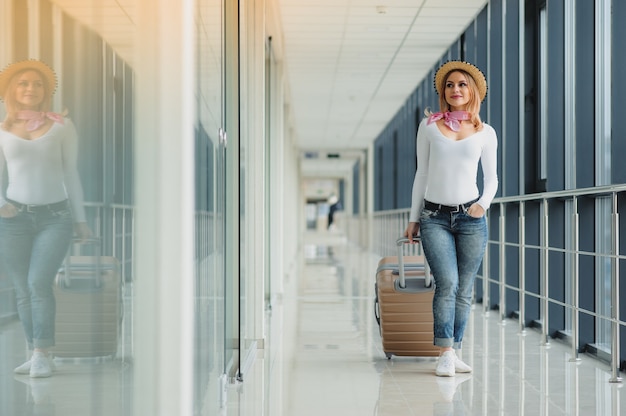 Mulher jovem e bonita com uma mala no aeroporto