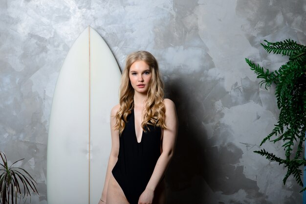Mulher jovem e bonita com uma prancha de surf
