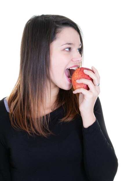 Mulher jovem e bonita comendo maçã vermelha isolada no fundo branco