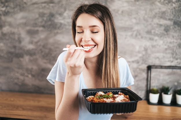 Mulher jovem e bonita comendo massa italiana.