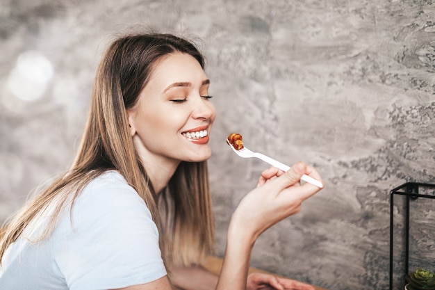 Foto mulher jovem e bonita comendo massa italiana.