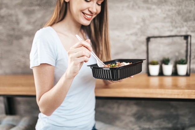 Mulher jovem e bonita comendo massa italiana.