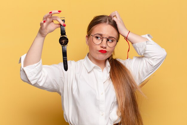 Mulher jovem e bonita. conceito de puntualidade de expressão pensando ou duvidando