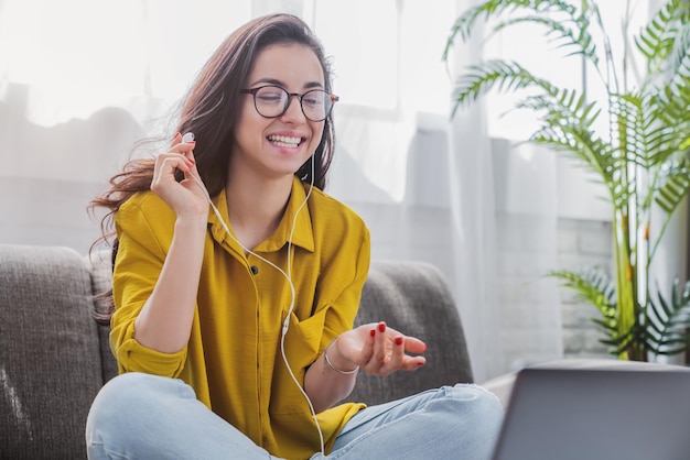 Mulher jovem e bonita conversando com pessoas no laptop usando videochamada