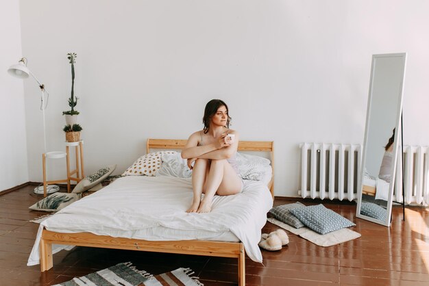 Mulher jovem e bonita de pijama a dormir a descansar na cama de manhã em casa.