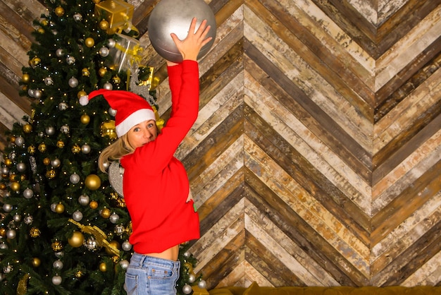 Mulher jovem e bonita decorando a árvore de natal