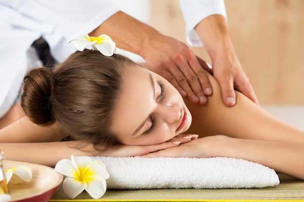 Mulher jovem e bonita deitada no salão spa. Cuidados com a pele e corpo, estilo de vida saudável, relaxamento, conceito de massagem e cosmetologia