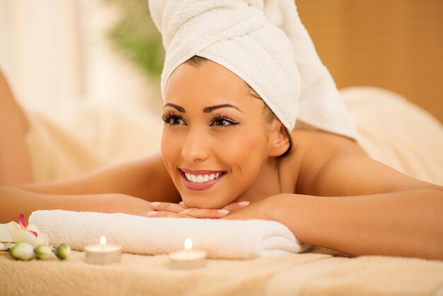 Mulher jovem e bonita desfrutando durante um tratamento de cuidados com a pele em um spa.