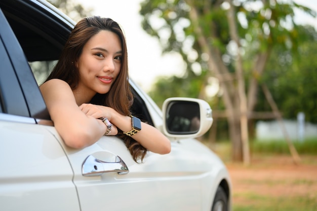 Mulher jovem e bonita dirigindo um carro