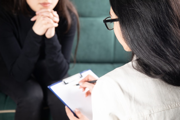 Mulher jovem e bonita discutindo seus problemas com uma psicóloga