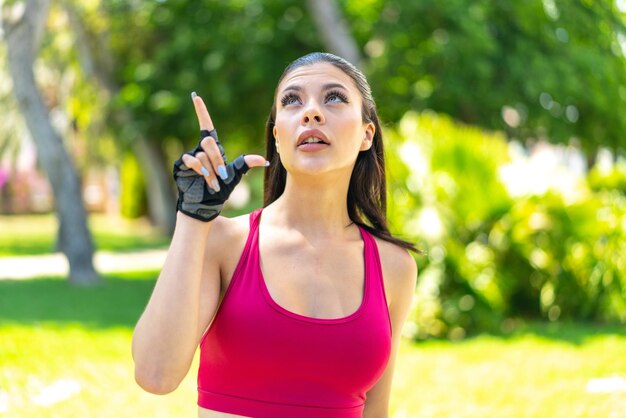 Mulher jovem e bonita do esporte ao ar livre com a intenção de perceber a solução enquanto levanta um dedo