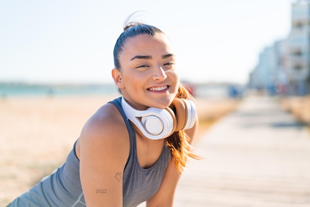 Foto mulher jovem e bonita do esporte vestindo roupas esportivas com expressão feliz