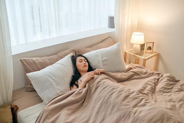 Mulher jovem e bonita dormindo na cama