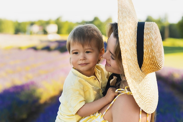 Mulher jovem e bonita e seu filho pequeno no campo de lavanda