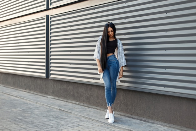 Mulher jovem e bonita elegante com longos cabelos negros em uma capa branca elegante