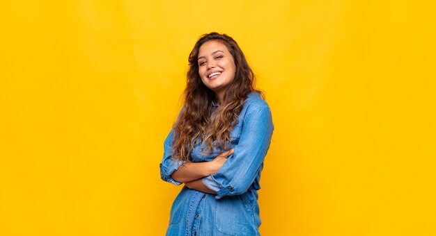 Mulher jovem e bonita elegante em fundo amarelo