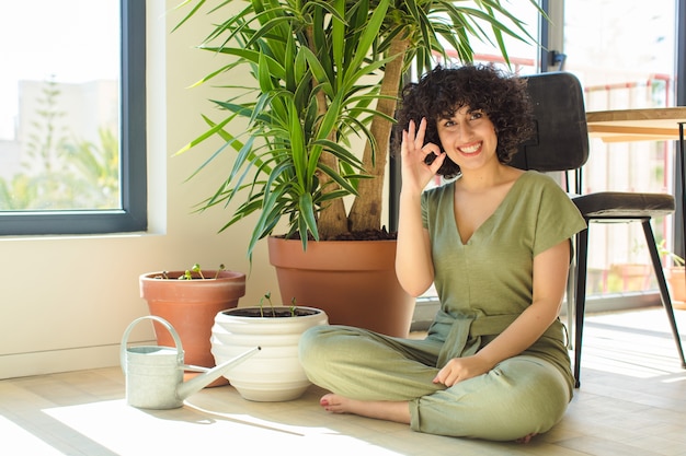 Mulher jovem e bonita em casa, com regador e plantas