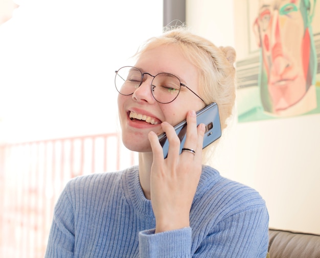 Mulher jovem e bonita em casa usando um telefone