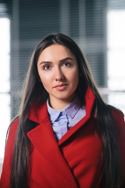 Mulher jovem e bonita em frente a um prédio de escritórios