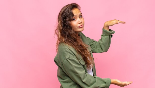 Foto mulher jovem e bonita em fundo rosa