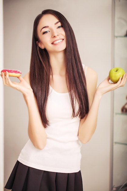 Mulher jovem e bonita escolhe entre estilo de vida saudável e alimentos prejudiciais