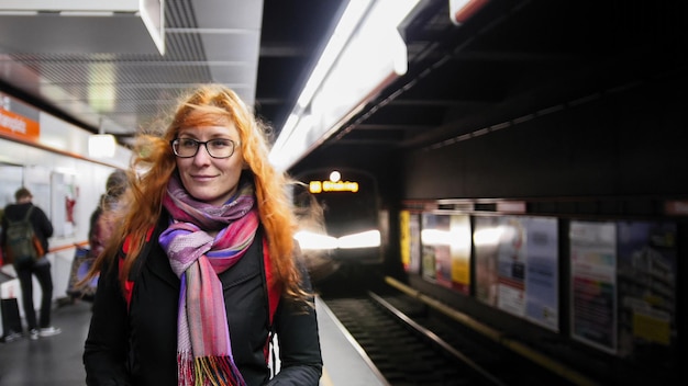 Mulher jovem e bonita esperando no metrô - o trem chega, grande angular