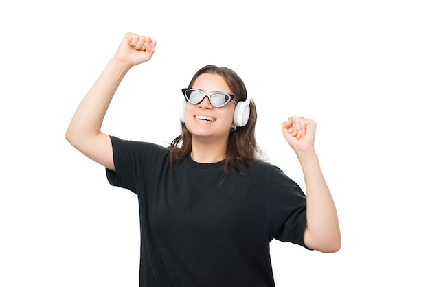 Mulher jovem e bonita está dançando enquanto ouve a música através de fones de ouvido.