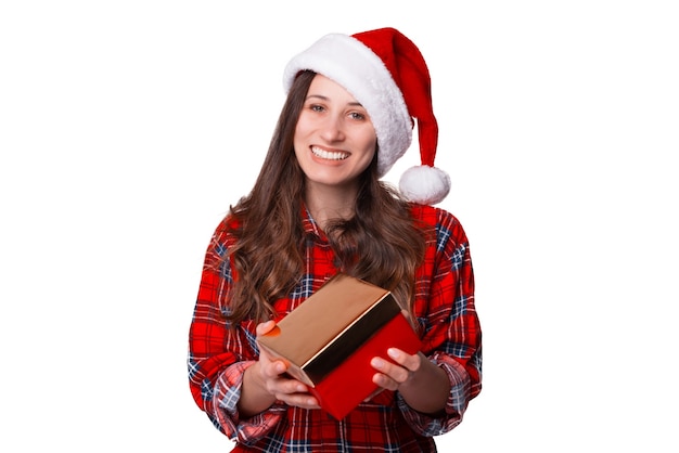Mulher jovem e bonita está dando um presente para a câmera enquanto usava um chapéu de natal.