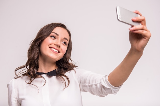 Mulher jovem e bonita está fazendo foto de selfie.