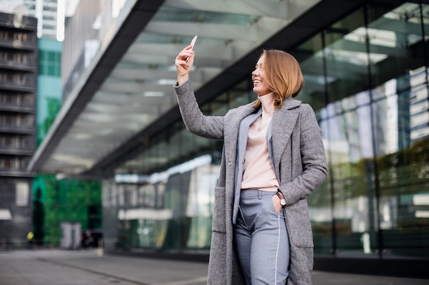 Foto mulher jovem e bonita está fazendo selfie foto com smartphone.