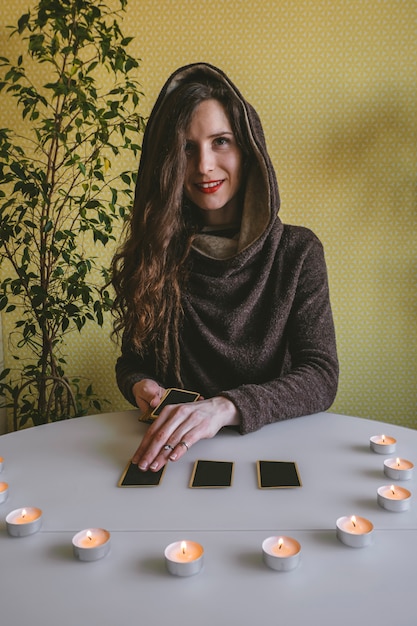 Mulher jovem e bonita estabelece cartões na mesa